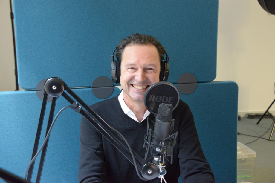 Auf dem Bild ist Alexander Kritikos im Podcast-Studio zu sehen. 