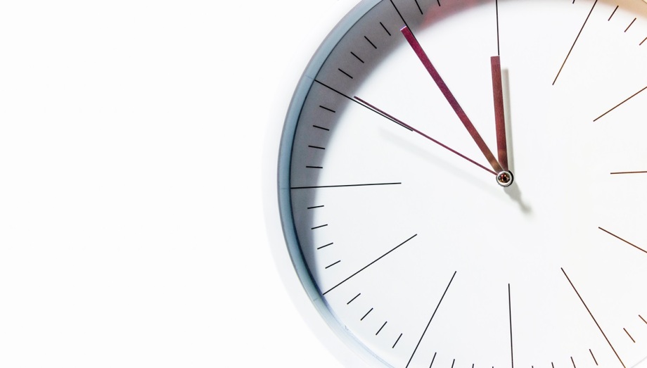 Wie zufrieden sind die Menschen in Deutschland mit ihrer Arbeitszeit? Dazu forschte das DIW Berlin.; Das Foto zeigt einen Ausschnitt einer modernen Wanduhr mit schlichtem Design. Die Uhr ist rund und hat ein weißes Zifferblatt ohne Zahlen, nur feine schwarze Striche markieren die Stunden und Minuten. Die Uhr ist so fotografiert, dass nur der rechte Teil sichtbar ist, während die linke Seite in einen weißen Hintergrund übergeht. Die Zeiger sind schlank und unterschiedlich gefärbt: der Stundenzeiger ist dunkel, der Minutenzeiger etwas heller, und der Sekundenzeiger ist sehr dünn. Die Uhr zeigt eine Zeit kurz nach 11 Uhr, etwa 11:08. Das Bild wirkt minimalistisch und klar, mit einem starken Kontrast zwischen dem weißen Hintergrund und den feinen Linien der Uhr.