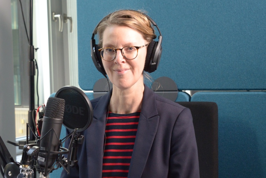 Dr. Bettina Böhm, Generalsekretärin der Leibniz-Gemeinschaft; Das Bild zeigt Dr. Bettina Böhm, Generalsekretärin der Leibniz-Gemeinschaft, die in einem Aufnahmestudio sitzt und sich auf eine Aufnahme vorbereitet. Die Person trägt Kopfhörer und spricht in ein Mikrofon.<br />
Visuelle Elemente:<br />
Person: Die Person trägt eine Brille und Kopfhörer.<br />
Sie ist in ein dunkles Blazer und ein rot-schwarz gestreiftes Hemd oder eine Bluse gekleidet.<br />
Mikrofon:<br />
Vor der Person befindet sich ein Mikrofon der Marke "RØDE".<br />
Das Mikrofon ist auf einem Ständer montiert und auf die Person ausgerichtet.<br />
Hintergrund:<br />
Der Hintergrund besteht aus einer blauen Wand, die typisch für ein Aufnahmestudio ist.<br />
Es gibt auch ein Mikrofonarm, der das Mikrofon hält.<br />
Zusätzliche Informationen:<br />
Das Bild vermittelt den Eindruck einer professionellen Aufnahmeumgebung, möglicherweise für Podcasts, Sprachaufnahmen oder Interviews.<br />
Die Person scheint sich auf eine Aufnahme oder ein Gespräch vorzubereiten.<br />
Diese Beschreibung bietet einen Überblick über die Szene einer Person, die sich in einem professionellen Aufnahmeumfeld befindet.