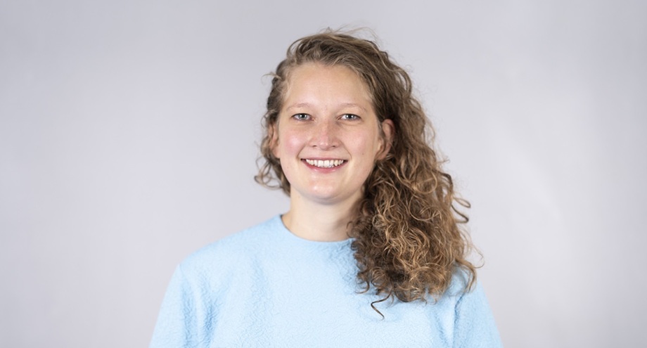 Clara Schäper ist seit 2020 als Doktorandin am DIW Berlin Graduate Center. Ihre Forschungsinteressen liegen im Bereich der Gender- und Familienökonomie, Arbeitsökonomie, angewandte Mikroökonometrie sowie in der Schnittstelle dieser Bereiche.; Das Bild zeigt eine Frau mit mittellangem, lockigem, braunem Haar, die leicht nach rechts blickt und ein hellblaues Oberteil trägt. Der Hintergrund des Bildes ist grau. Die Frau auf dem Bild ist Clara Schäper.