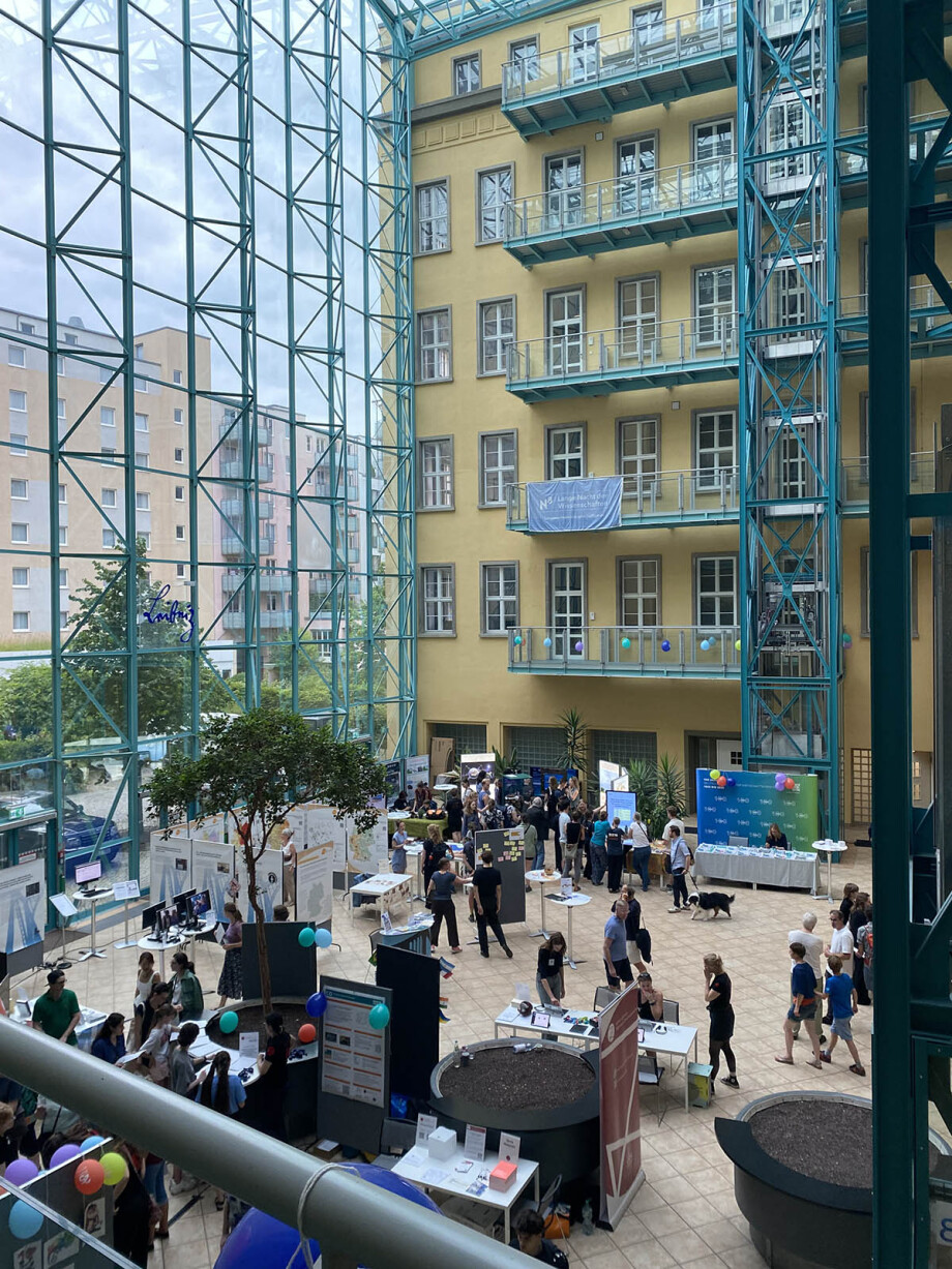 Atrium der Leibniz Gemeinschaft mit Besucher*innen der Langen Nacht der Wissenschaften und dem DIW Berlin Infostand
