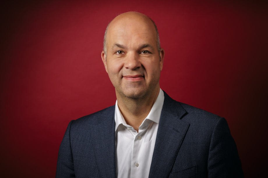 Auf dem Foto ist Marcel Fratzscher, Präsident des DIW Berlin, vor rotem Hintergrund zu sehen.