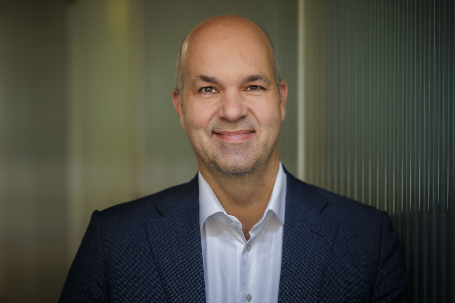 Auf dem Foto ist Marcel Fratzscher, Präsident des DIW Berlin, vor einer welligen Wand zu sehen.